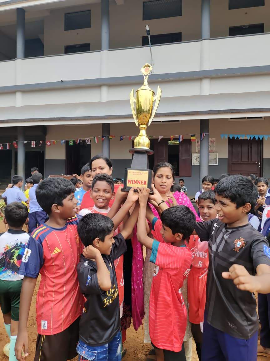 Students holding the winners' trophy after the inter-house tournament